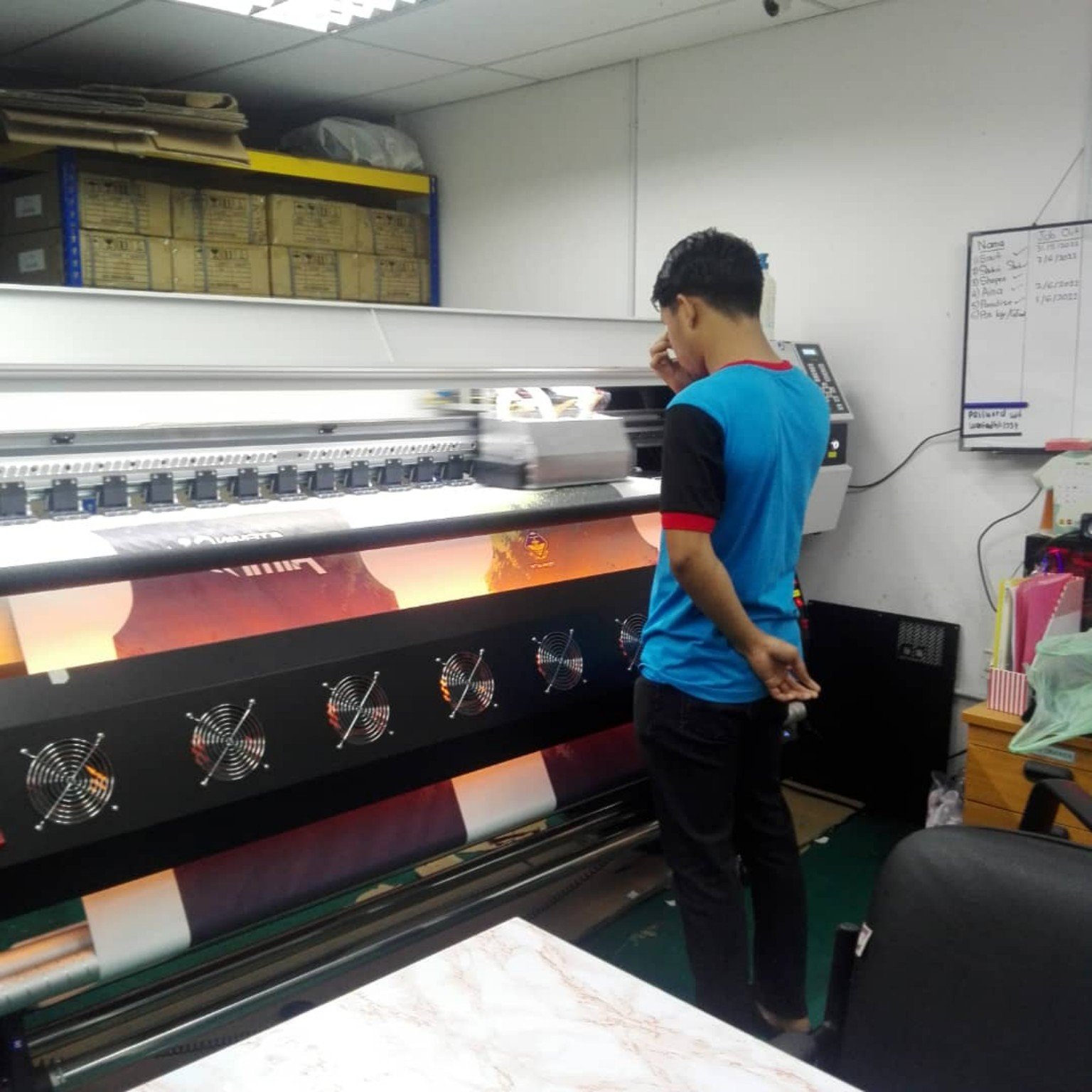 Operator mengendalikan mesin cetak sublimation Saudagar Printing Malaysia