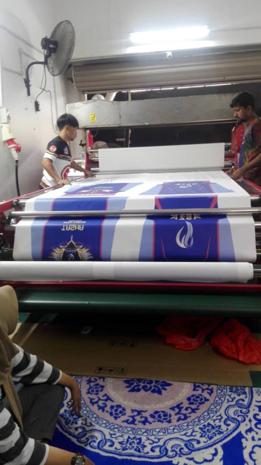 Proses heat press fabrik sublimation di kilang Saudagar Printing Malaysia